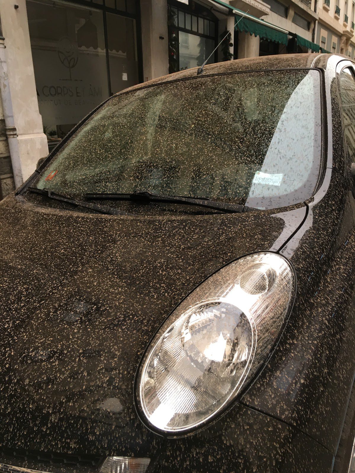 Photo of the car covered by dust from yellow rain.