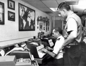 Senior Master Sgt. Luis Montanez and Major Michael Ennis of the U. S. Air Force, (left to right), at the operating position in the Washington Terminal of the Washington-Moscow Direct Communications Link known as the Hat Line.