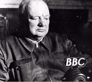 Sir Winston Churchill sitting in front of the radio microphone, with BBC sign on it.