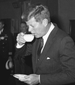 A photo of US President John Fitzgerald Kennedy taking a sip of coffee
